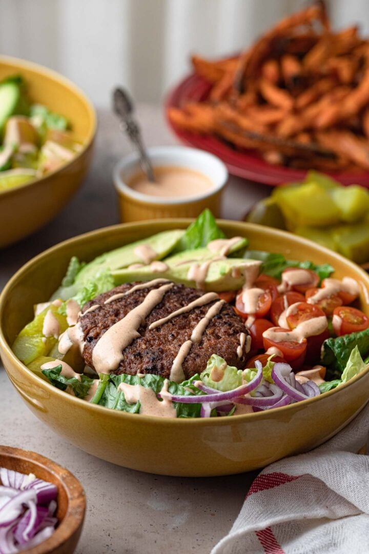 Two plant-based burger bowls, drizzled with special sauce!