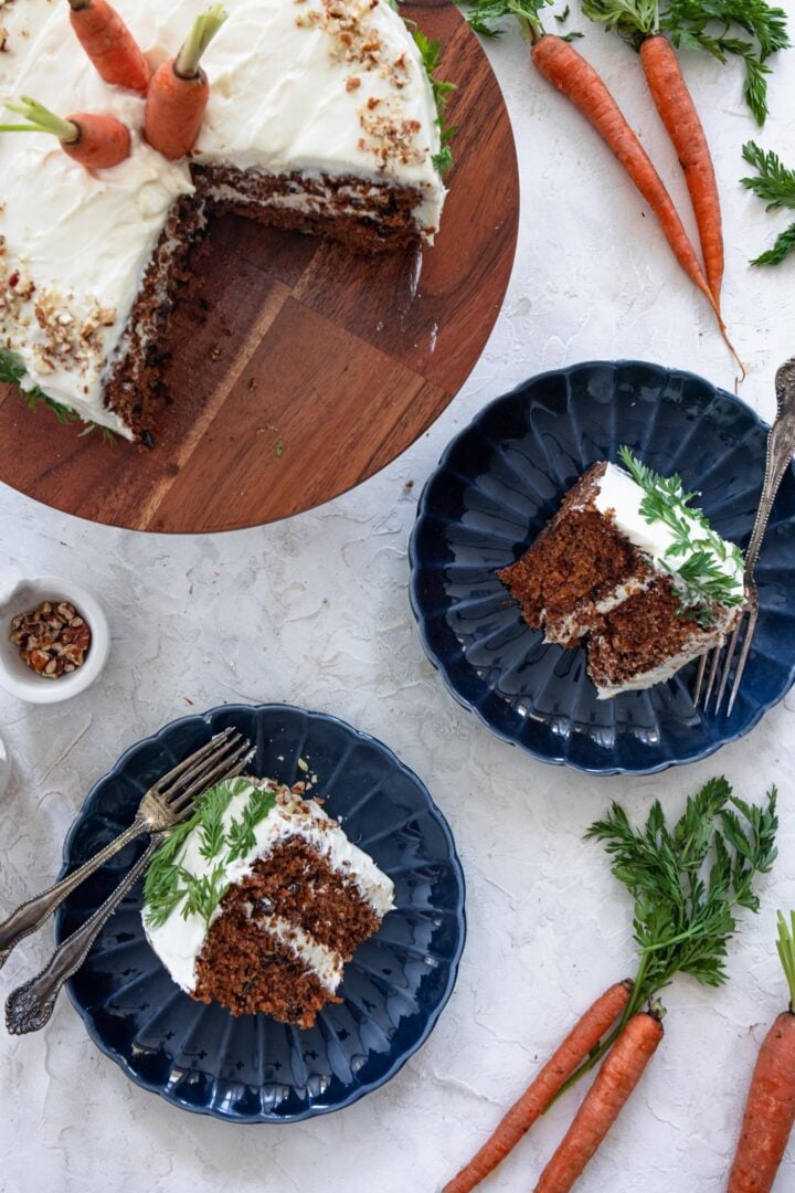 An overhead shot of a cut carrot cake and two individual carrot cake slices.