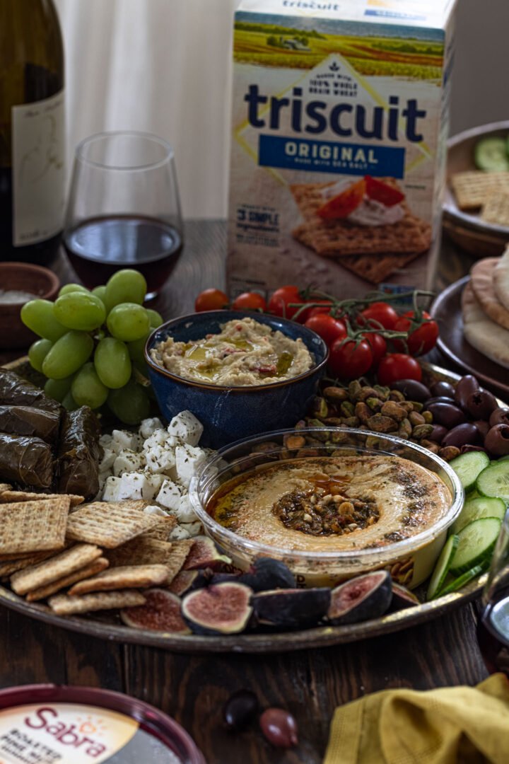 A mezze platter on a table with a box of TRISCUIT crackers.