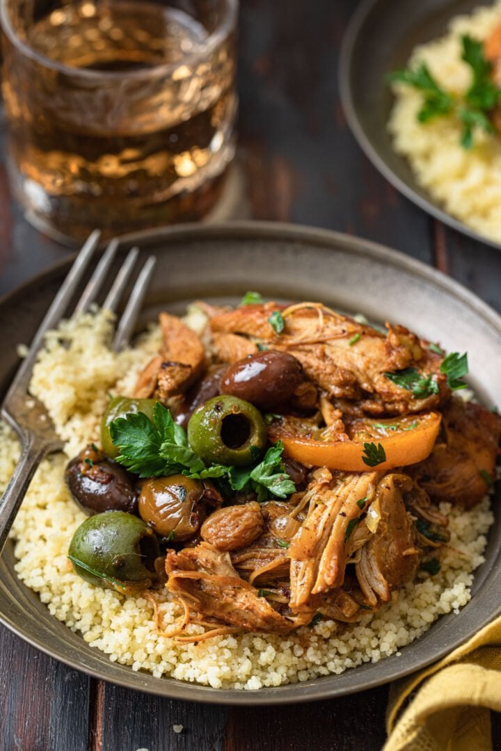 A close up shot of an individual serving of chicken tagine served over couscous.