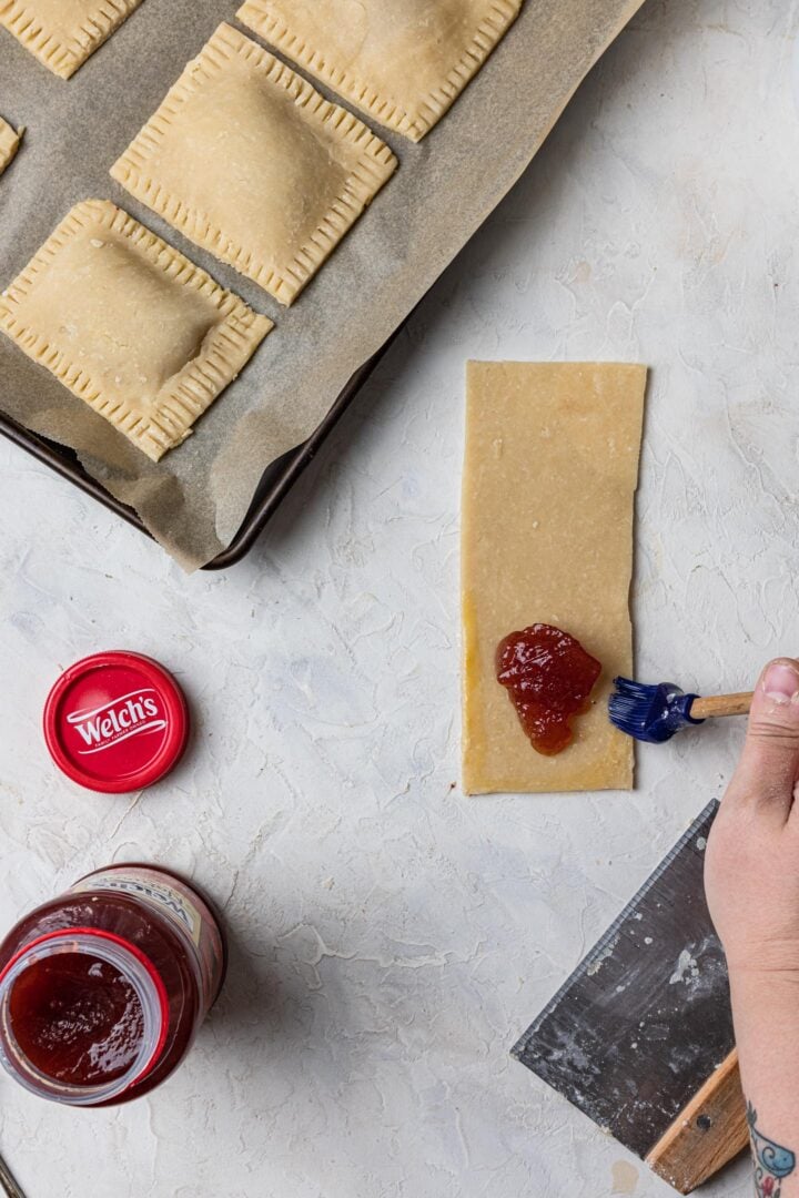 Brushing pastry with egg wash.