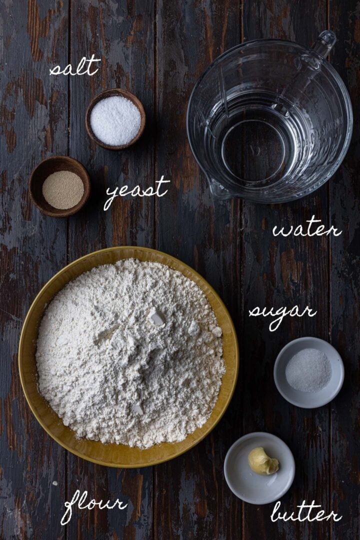 A photo of all the ingredients to make Brazilian bread rolls. Flour, yeast, water, sugar, salt and butter.