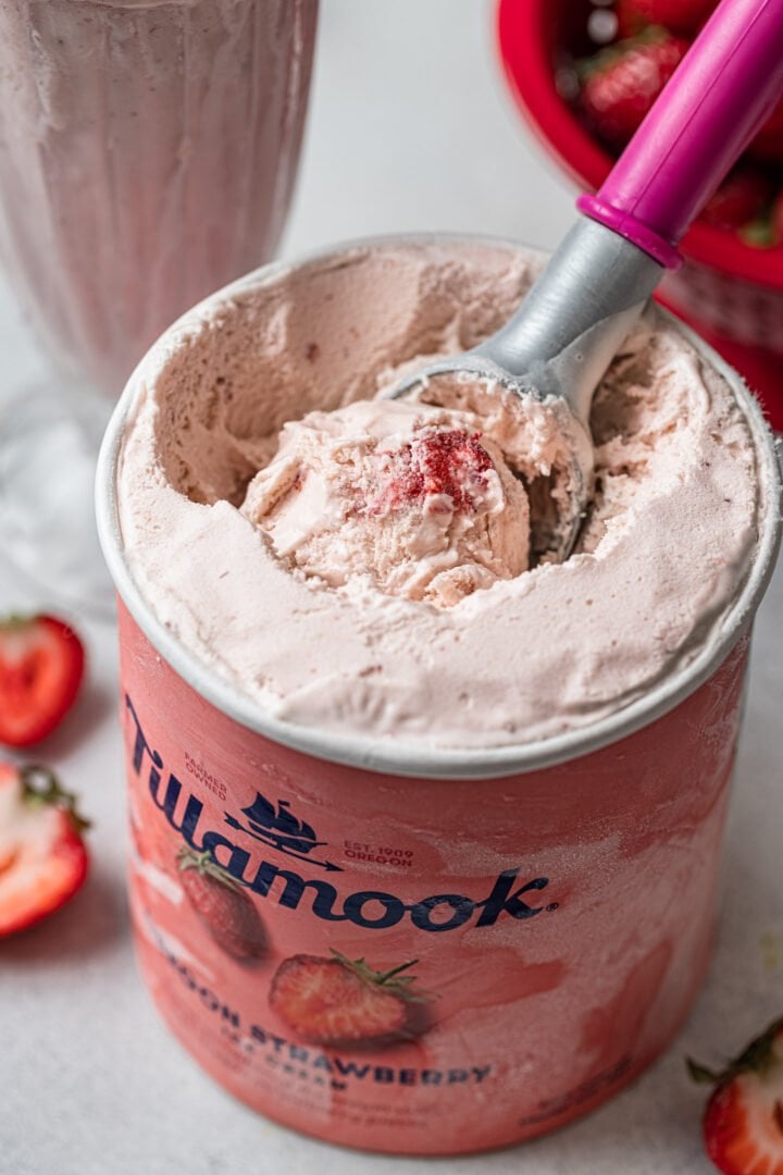 A close up shot of a carton of Tillamook strawberry ice cream.