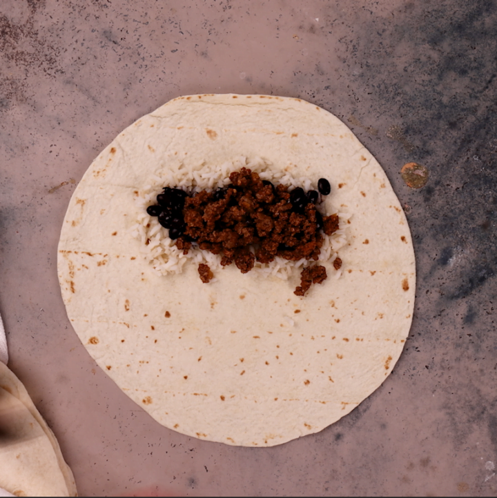 Assembling the beef burrito. Third layer: ground beef.