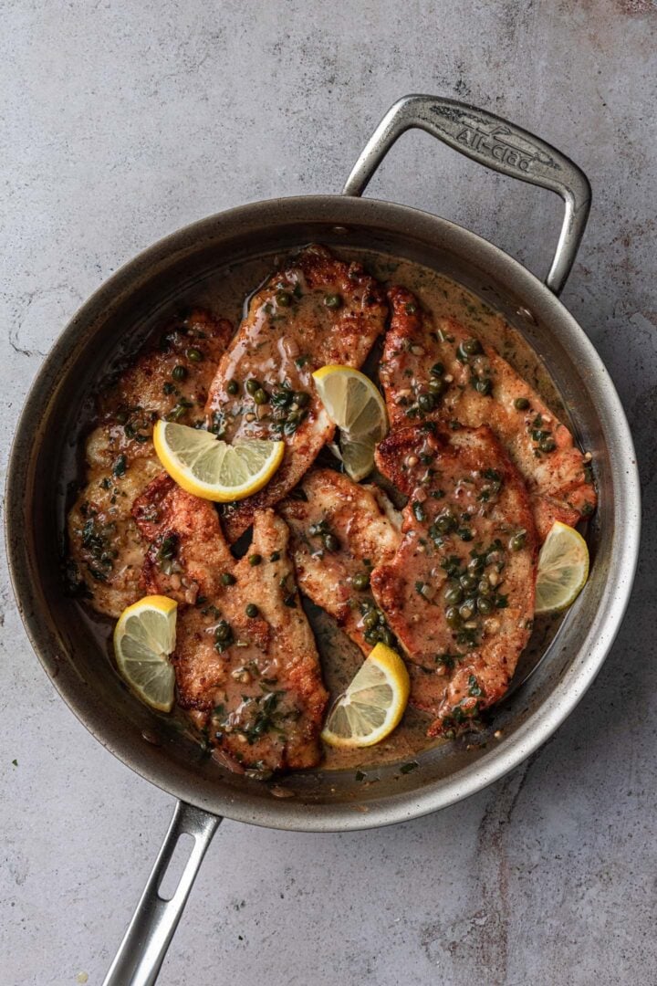 Chicken back in the pan with the piccata sauce.