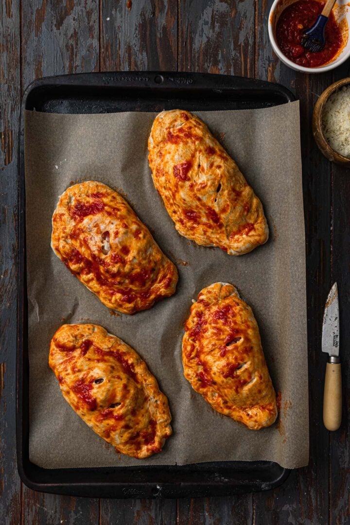 Making vent cuts on each calzone.