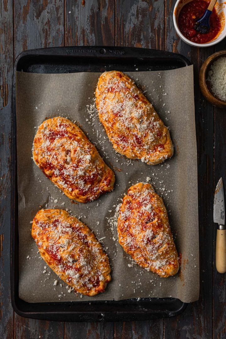 Calzoni topped with parmesan cheese.