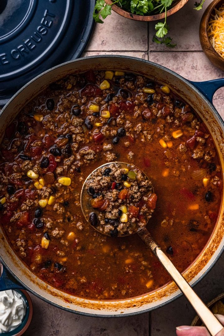 A close up of a ladleful of taco soup.