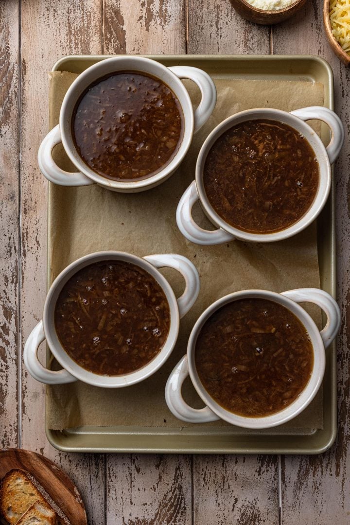 Four soup bowls on a baking sheet.