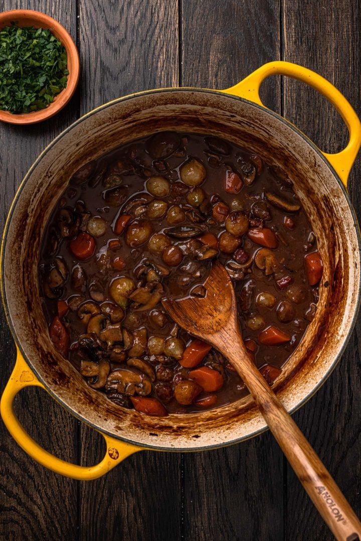 Wine sauce garnished with the pearl onions and mushrooms.