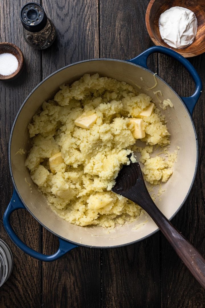 Stirring the butter into the potatoes.