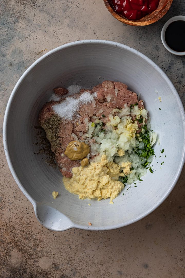 Combining the meatloaf ingredients in a bowl.