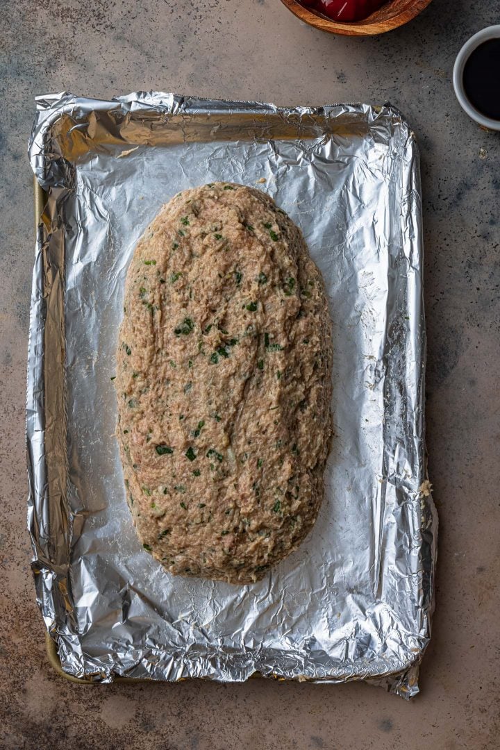 The shaped meatloaf on a baking sheet lined with foil.