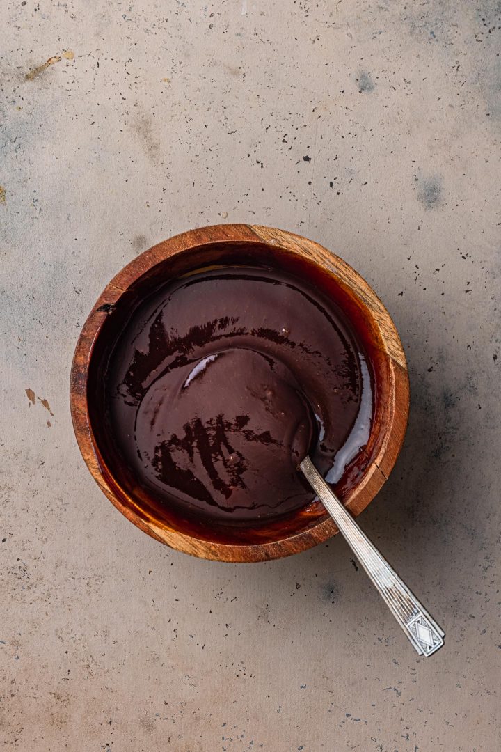 The balsamic glaze in a bowl with a spoon.