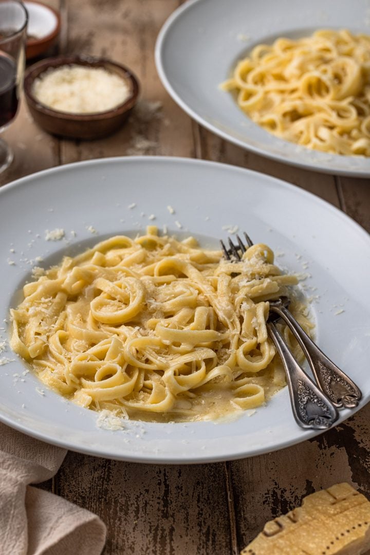 A bowl of authentic fettuccine Alfredo garnished with parmesan.