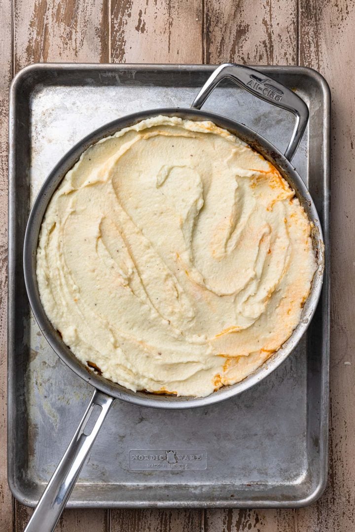 Assembling the shepherd's pie: spreading the mashed potatoes on top of the filling.