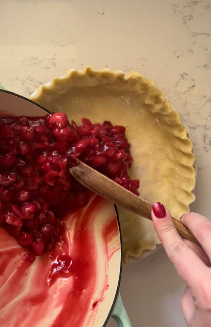 Adding the filling to the pie crust.