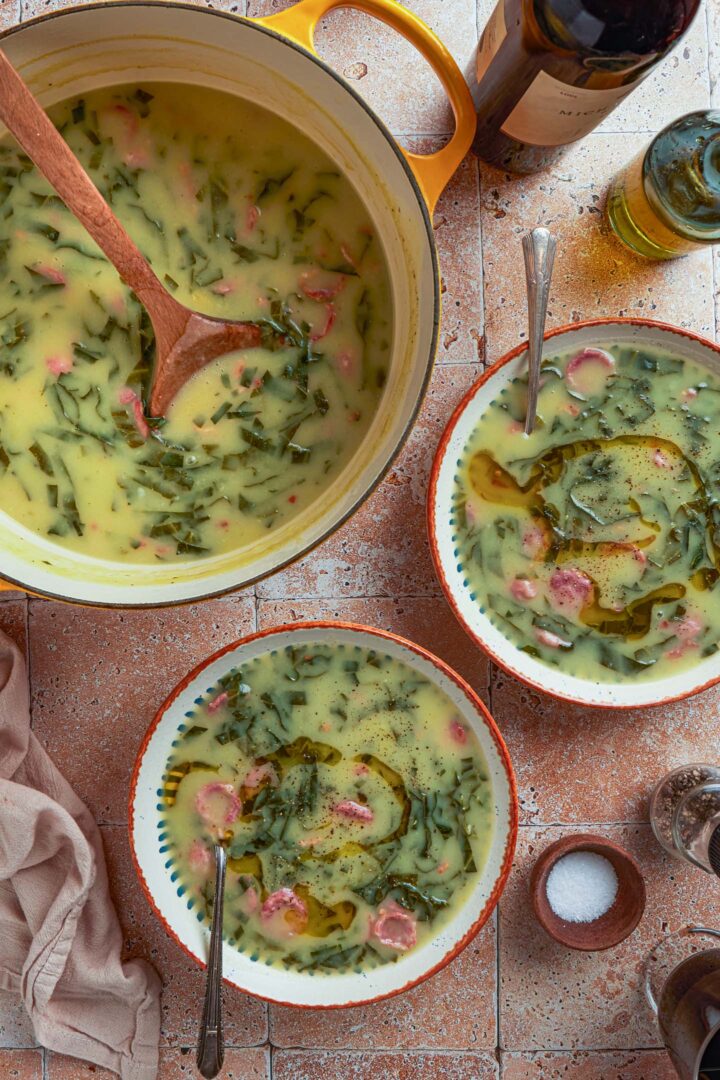A serving scene: a pot of caldo verde and two bowls of individual servings of this Portuguese soup.