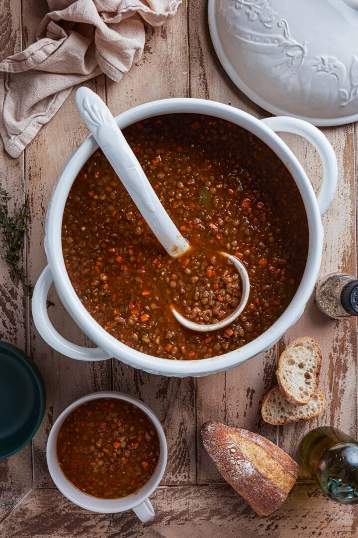 A soup tureen with lentil soup, with a ladle.
