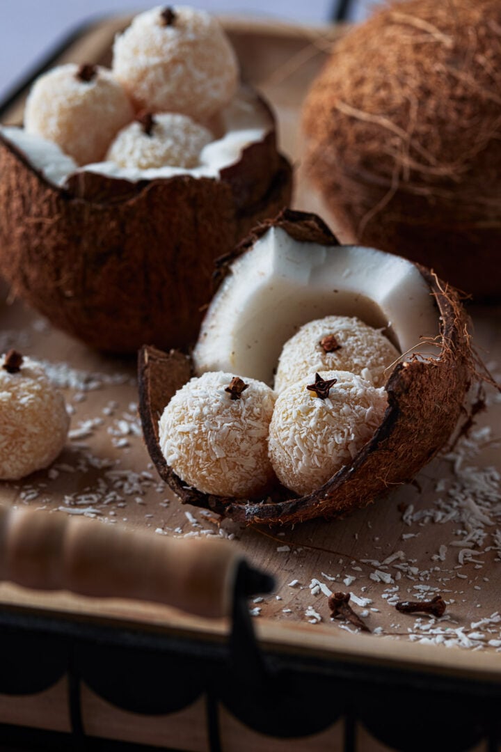 Three beijinhos inside a cracked coconut. 