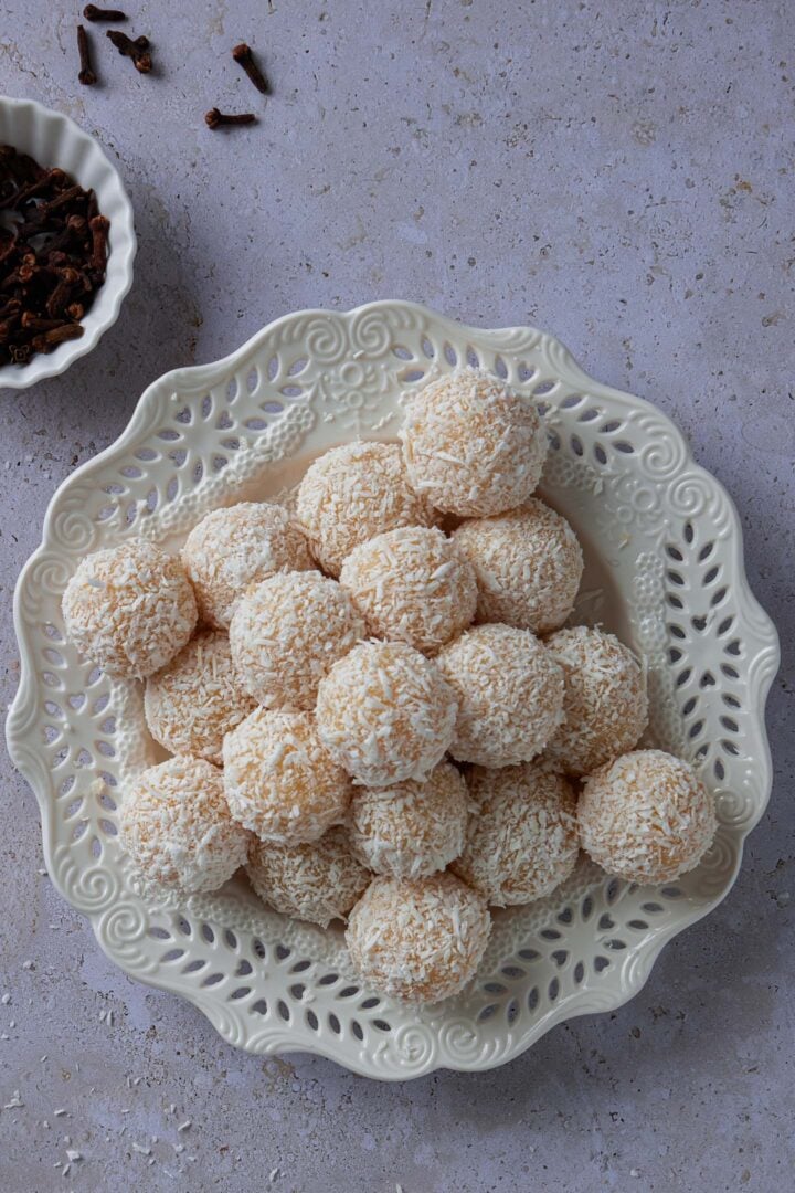 A platter of beijinhos. You can also see a small bowl of cloves and some cloves scattered on the table.