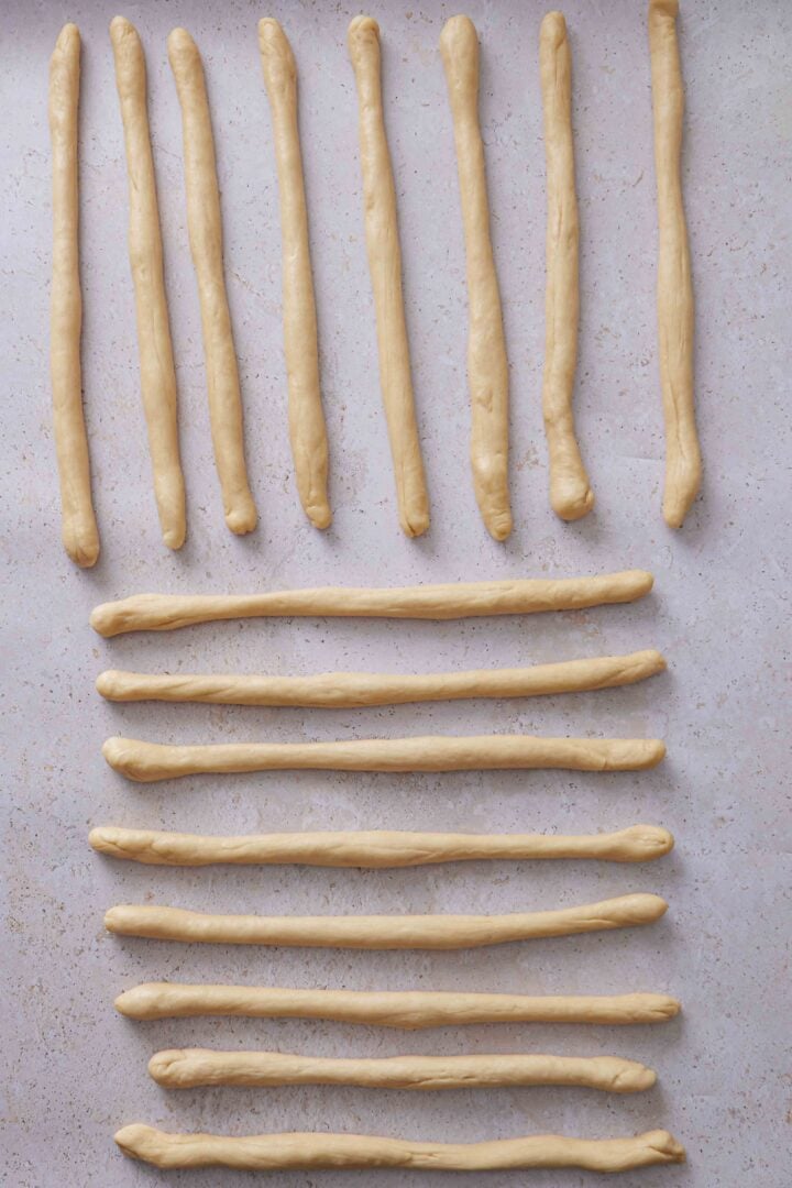Overhead photo of dough pieces rolled into long ropes for shaping the buns.