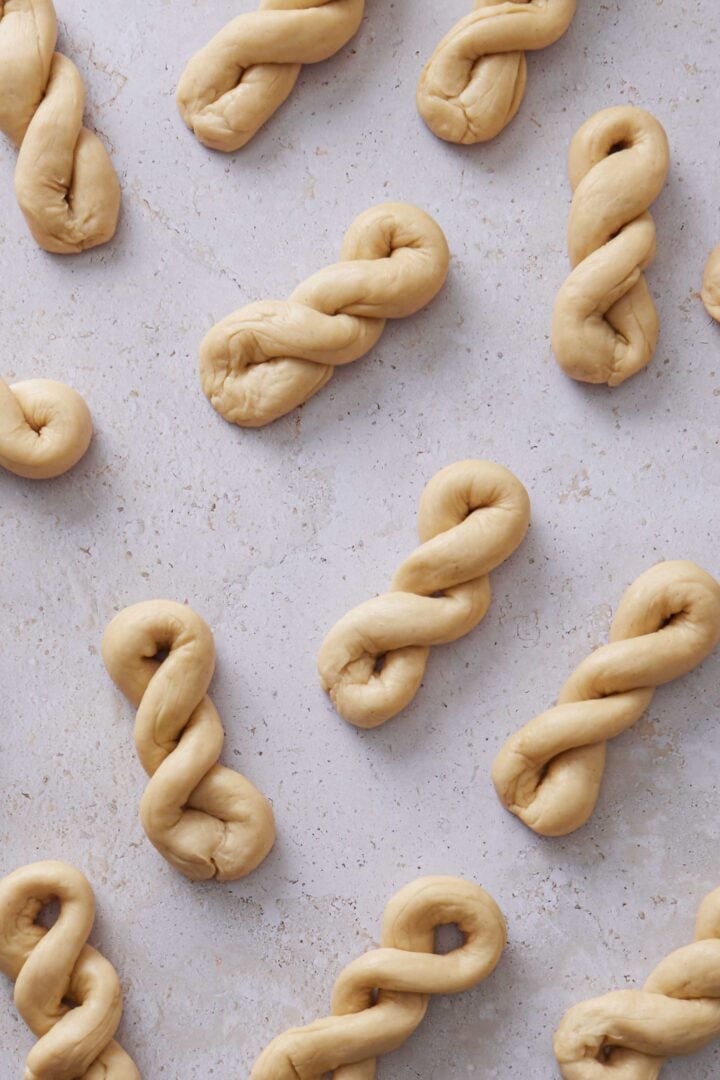 Overhead photo of several shaped twisted buns on the counter before being arranged in the baking dish.