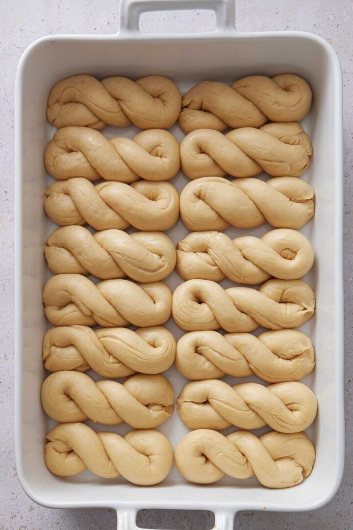 Overhead photo of the shaped buns after the second rise, puffed up and filling the baking dish.