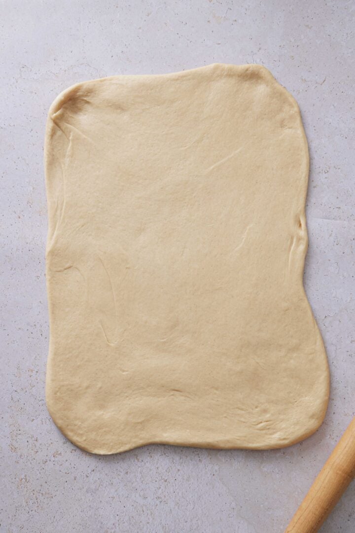 Overhead photo of the dough pressed into a rectangle on the counter, ready to be cut for shaping.