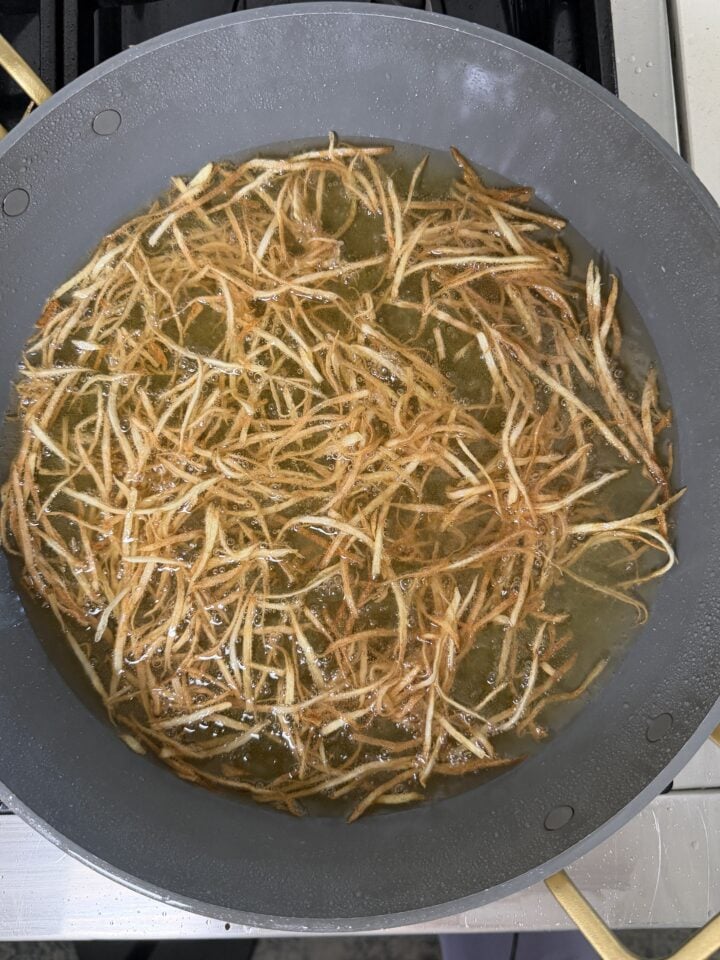 Frying the potatoes in oil.