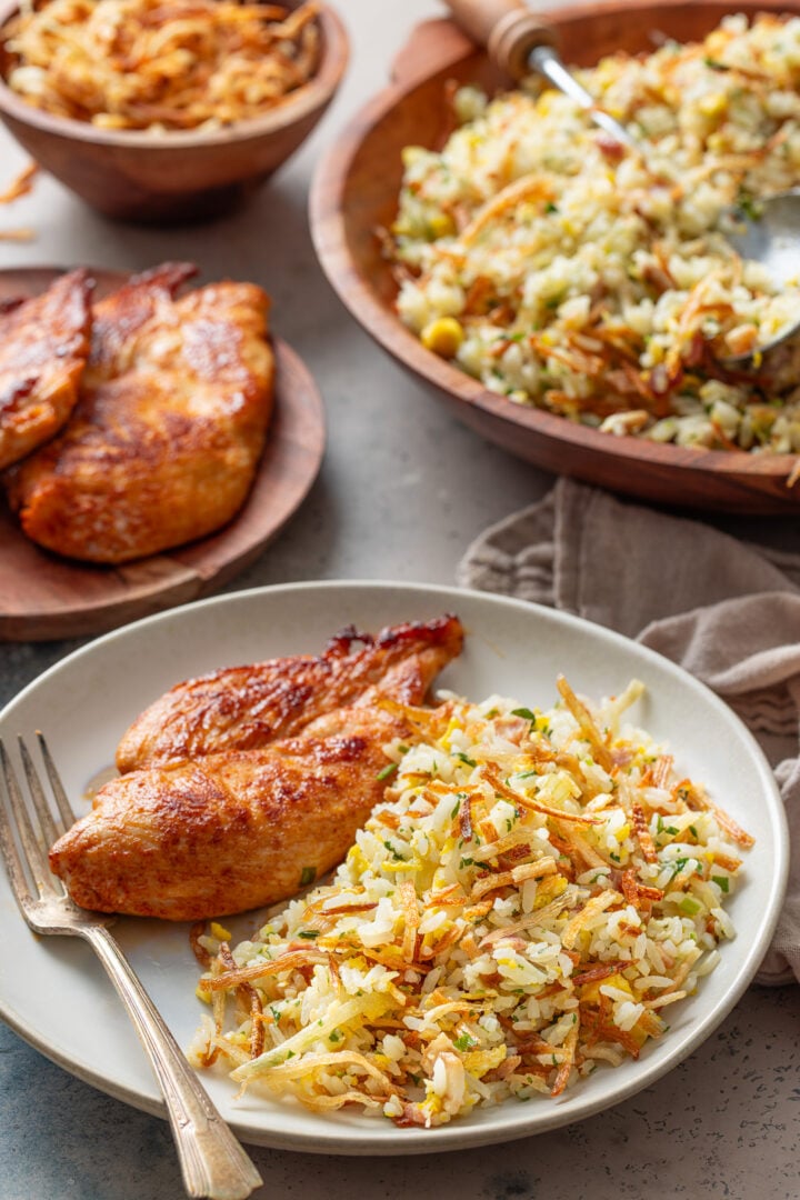 Arroz biro biro served with grilled chicken, Brazilian fried rice with bacon, eggs, and batata palha