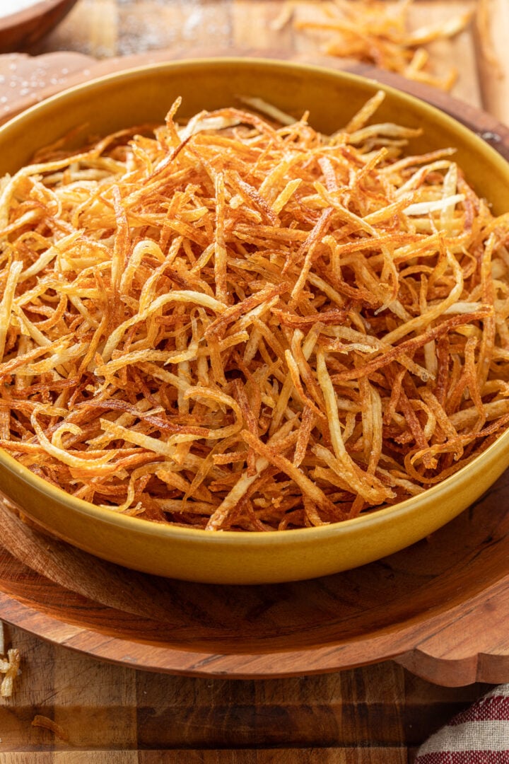 Homemade Brazilian batata palha piled high in a bowl.