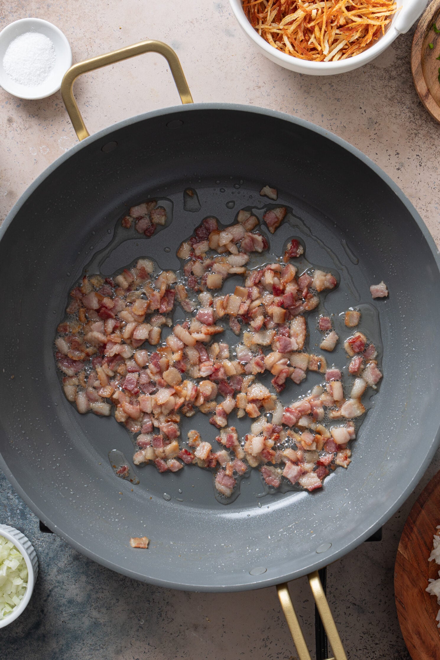 Diced bacon cooking in a skillet for arroz biro biro