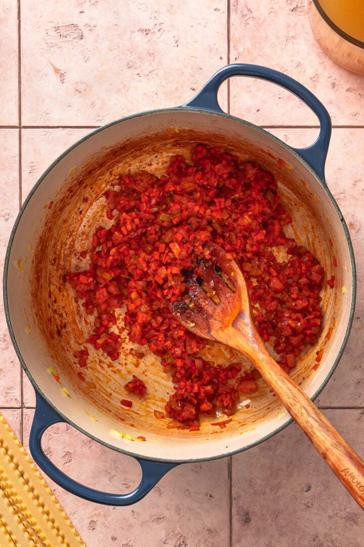Tomato paste cooking with vegetables to deepen flavor