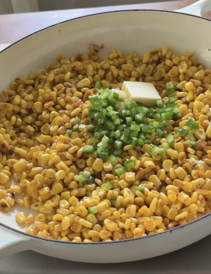 Corn sautéed with butter and chopped jalapeño in a skillet for Mexican street corn dip