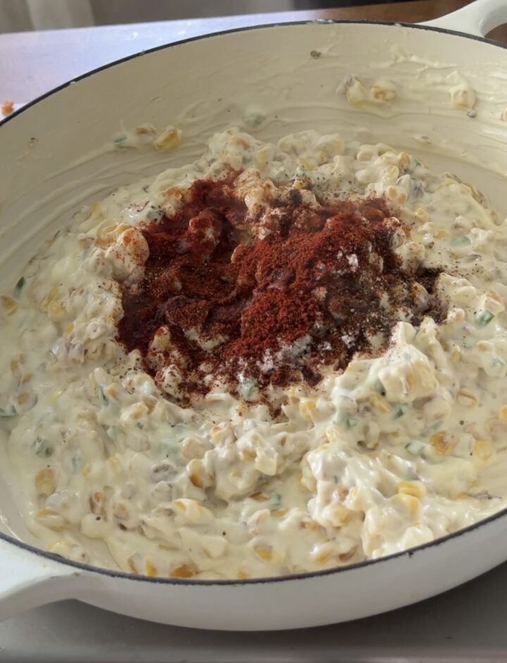 Mexican street corn dip mixture topped with chili powder, paprika, and spices before mixing