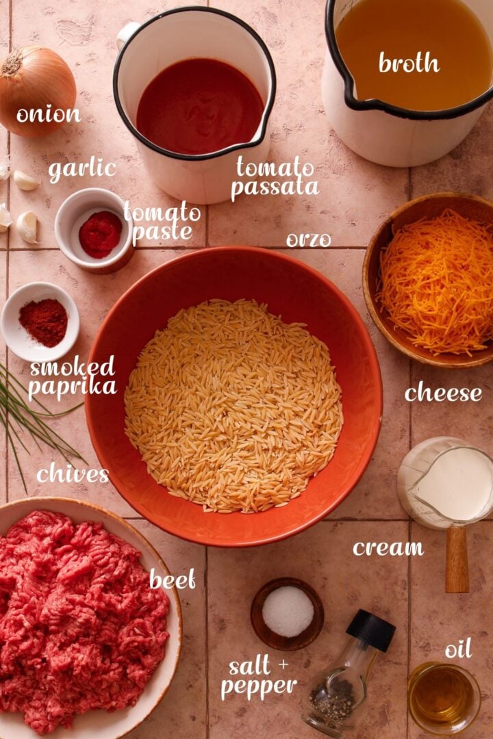 Ingredients for creamy ground beef orzo including ground beef, orzo, tomato passata, cheddar cheese, broth, cream, onion, garlic, and seasonings.