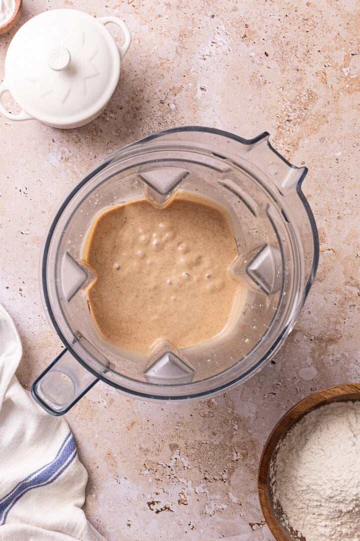 Blended cinnamon cake batter in a blender pitcher for homemade churro cake.