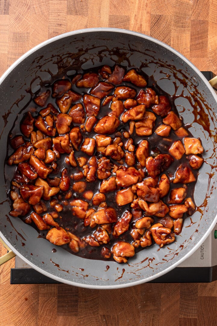 Chicken pieces coated in thick homemade teriyaki sauce in a skillet viewed from above.