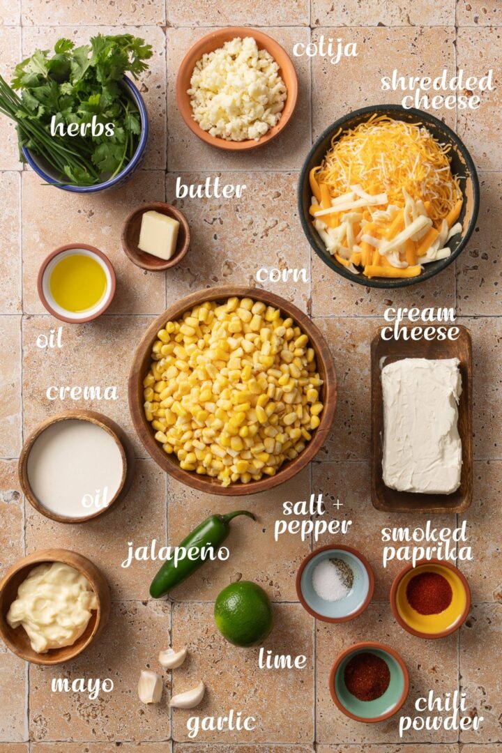 Ingredients for Mexican street corn dip including corn, cream cheese, shredded cheese, cotija, jalapeño, lime, garlic, crema, mayo, and spices