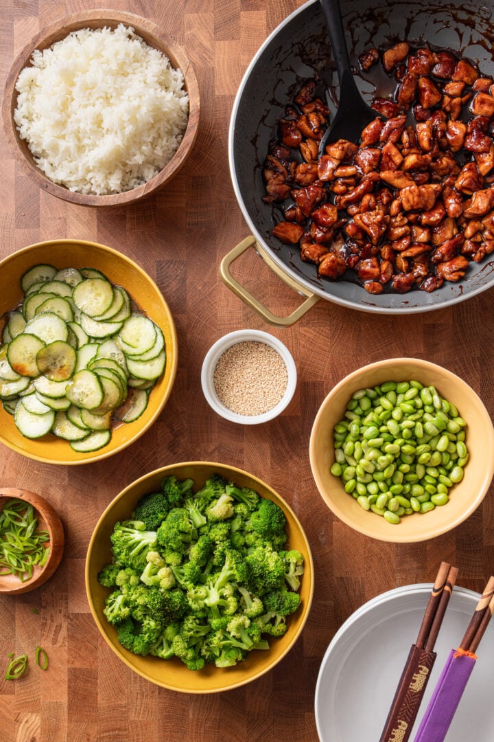 Homemade chicken teriyaki rice bowls served family-style with rice, vegetables, and toppings.